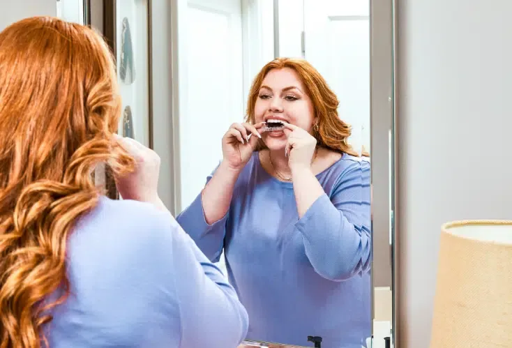 A clear SureSmile aligner being held up to the light